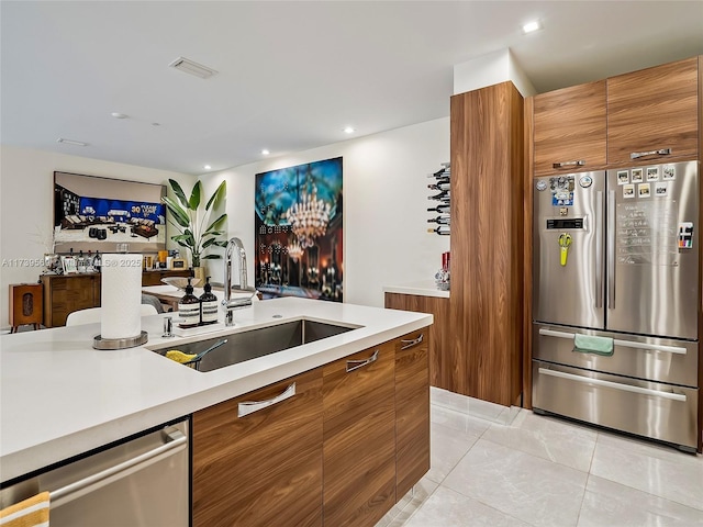 kitchen with light tile patterned flooring, appliances with stainless steel finishes, and sink