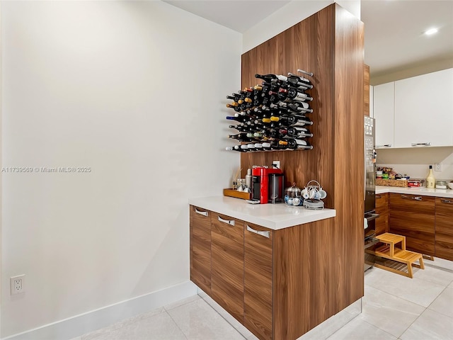 bar featuring light tile patterned flooring and white cabinets