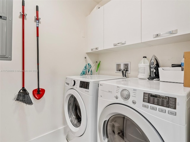 clothes washing area featuring washing machine and dryer, cabinets, and electric panel