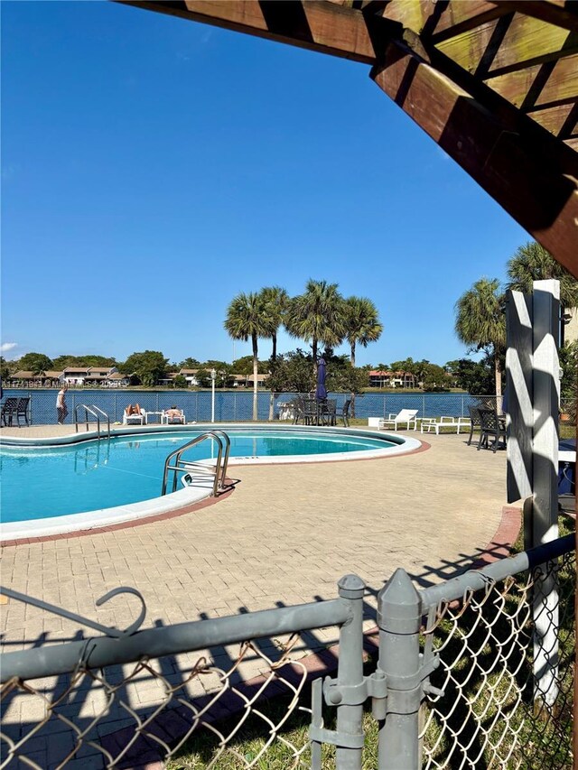 view of pool with a water view and a patio area