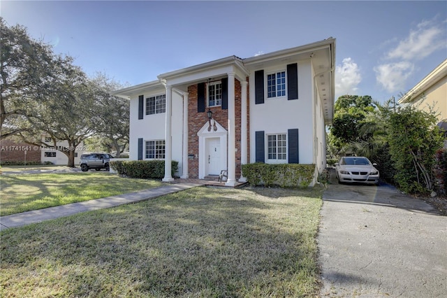 greek revival inspired property featuring a front lawn