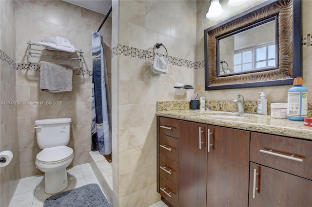 bathroom featuring curtained shower, tile walls, vanity, toilet, and tile patterned floors