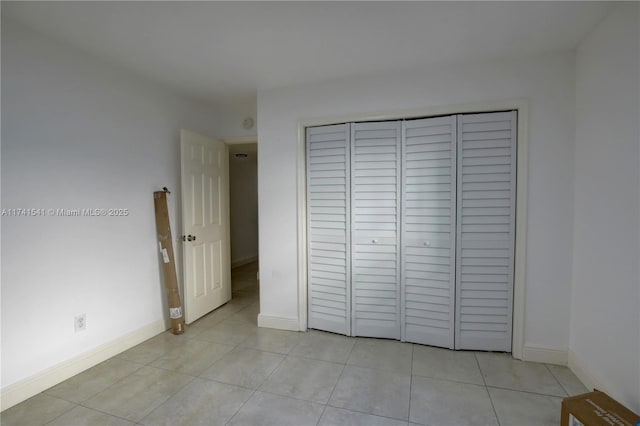 unfurnished bedroom with light tile patterned flooring and a closet