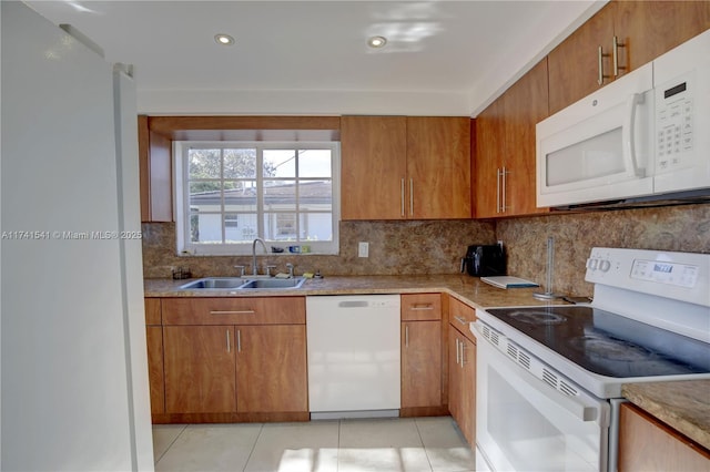 kitchen with tasteful backsplash, white appliances, sink, and light tile patterned floors