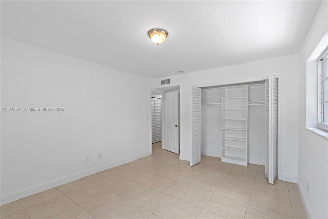 unfurnished bedroom featuring light tile patterned flooring and a closet