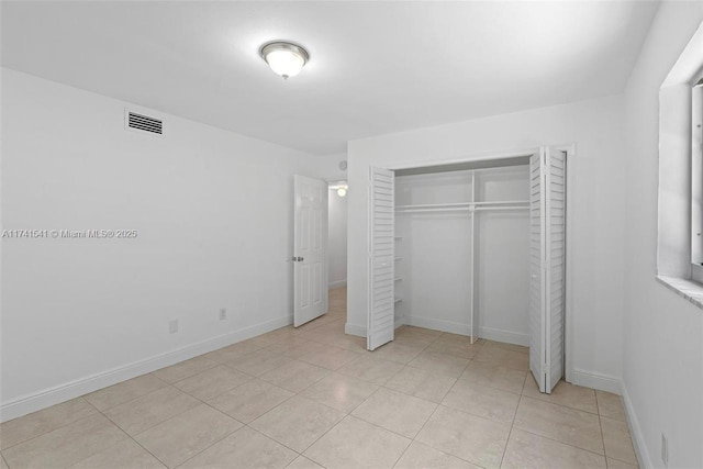 unfurnished bedroom featuring light tile patterned floors and a closet