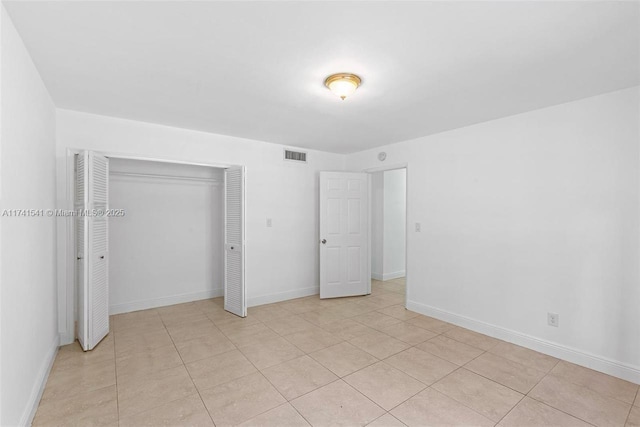 unfurnished bedroom with light tile patterned floors and a closet