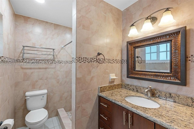 bathroom with vanity, toilet, tile walls, and walk in shower