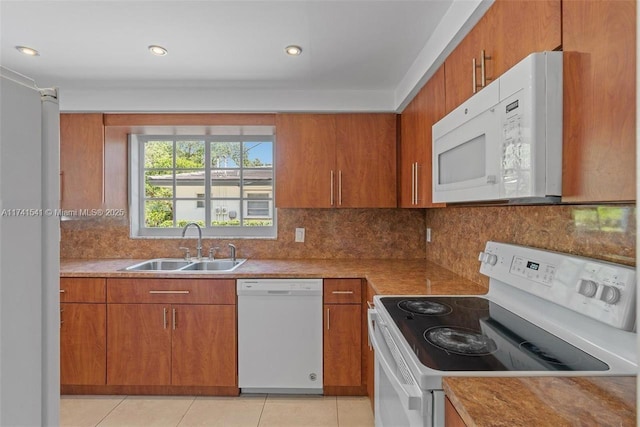 kitchen featuring tasteful backsplash, white appliances, sink, and light tile patterned floors