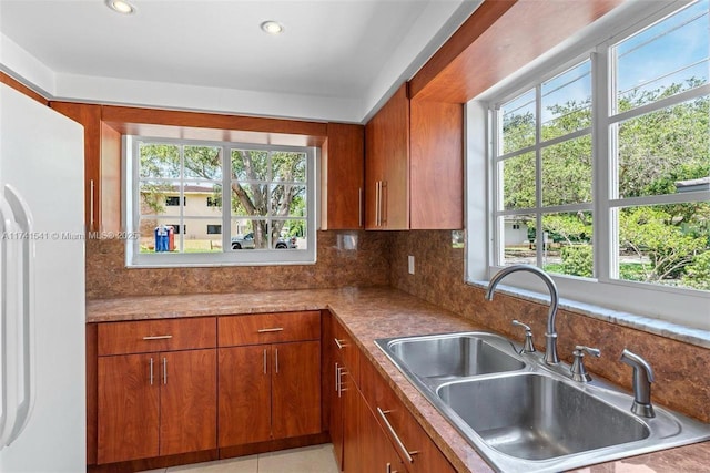 kitchen featuring tasteful backsplash, sink, and white fridge