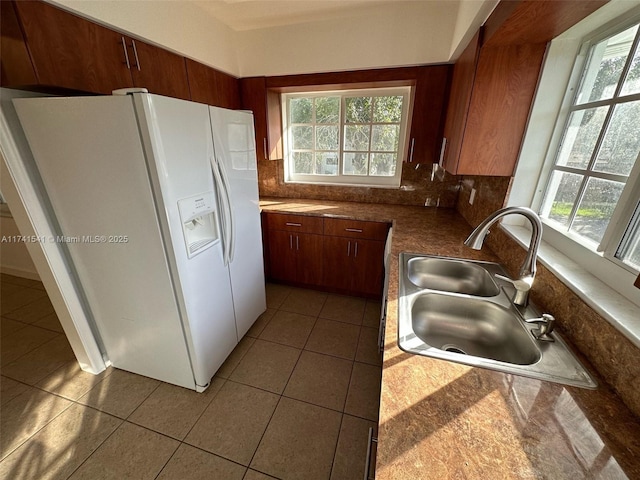 kitchen featuring tasteful backsplash, sink, tile patterned floors, and white fridge with ice dispenser