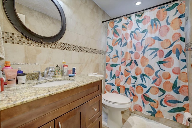 bathroom featuring tile walls, vanity, curtained shower, and toilet