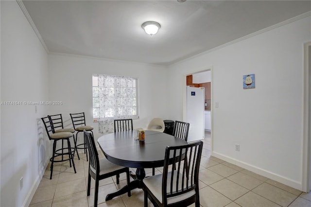 dining room with crown molding and light tile patterned flooring