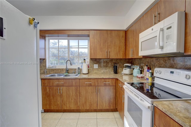 kitchen featuring tasteful backsplash, sink, light tile patterned floors, and white appliances