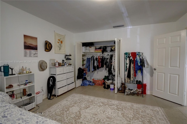 bedroom with light tile patterned floors and a closet