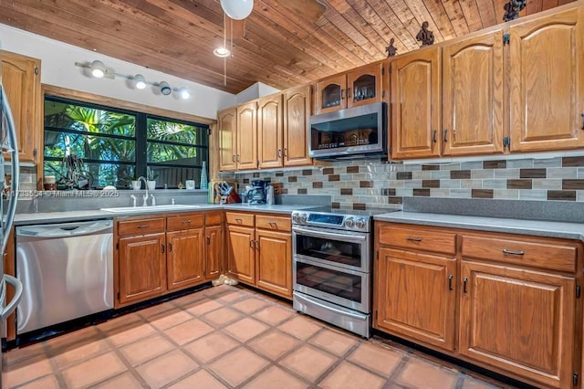 kitchen featuring sink, tasteful backsplash, vaulted ceiling, wooden ceiling, and appliances with stainless steel finishes