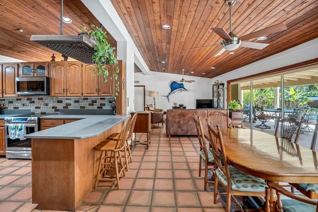 kitchen with wood ceiling, ceiling fan, appliances with stainless steel finishes, and decorative backsplash