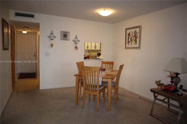 dining room with carpet floors and a textured ceiling