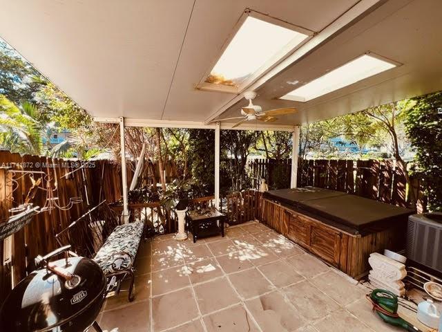 sunroom / solarium featuring ceiling fan and a skylight