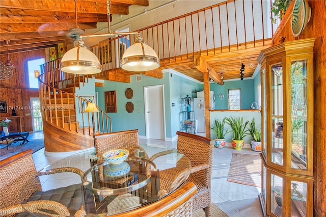 dining space featuring a towering ceiling and tile patterned floors