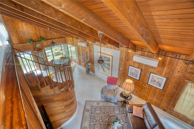 unfurnished living room with beam ceiling, a healthy amount of sunlight, and wooden walls