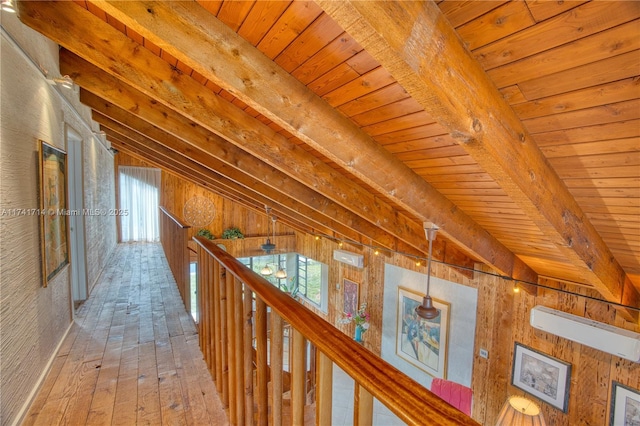 corridor featuring hardwood / wood-style floors, lofted ceiling with beams, wooden ceiling, and wooden walls