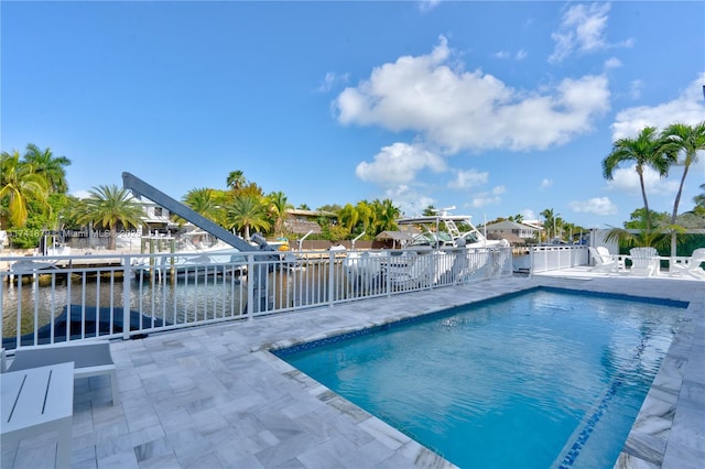 view of swimming pool with a patio and a water view