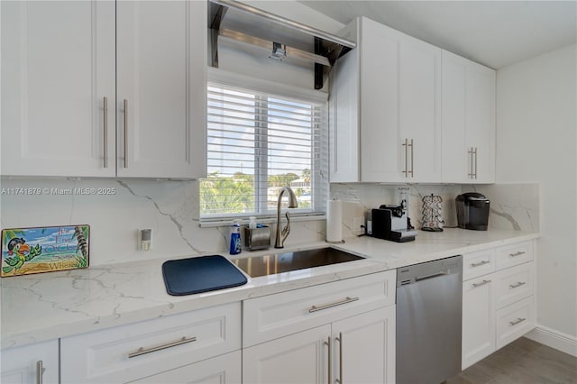 kitchen with sink, white cabinetry, tasteful backsplash, light stone counters, and stainless steel dishwasher