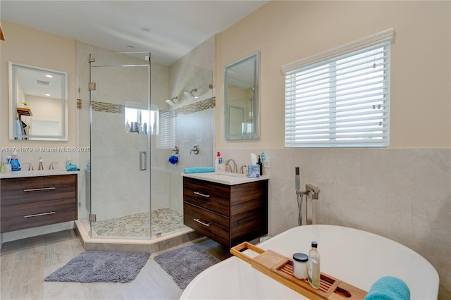 bathroom featuring vanity, plenty of natural light, and tile walls