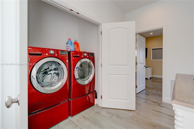 washroom with separate washer and dryer and light hardwood / wood-style floors