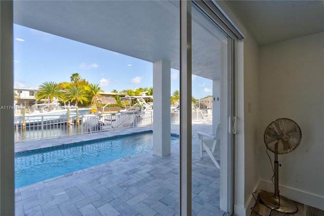 view of pool with a patio and a water view