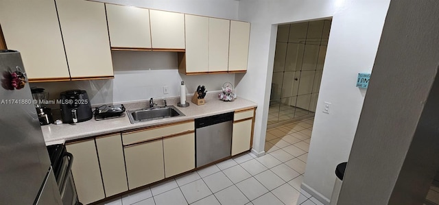 kitchen featuring stainless steel appliances, sink, and light tile patterned floors