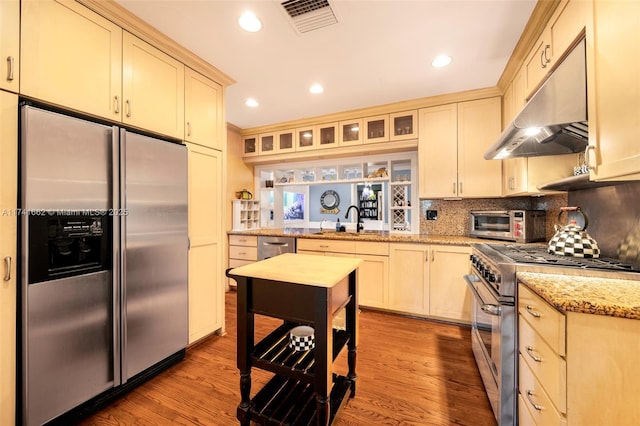 kitchen featuring sink, light wood-type flooring, light stone countertops, and appliances with stainless steel finishes