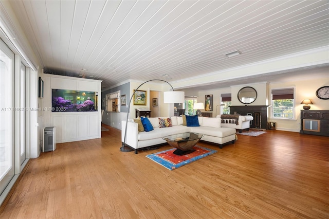 living room with crown molding, light hardwood / wood-style floors, and wooden ceiling