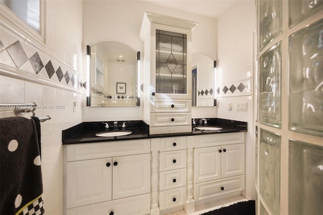 bathroom with tile walls, vanity, and tile patterned flooring