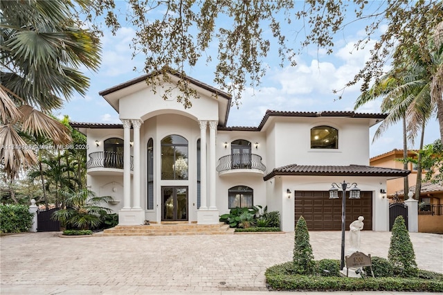 mediterranean / spanish-style home featuring a garage and a balcony