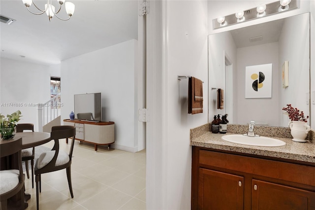 bathroom featuring tile patterned flooring, visible vents, baseboards, an inviting chandelier, and vanity