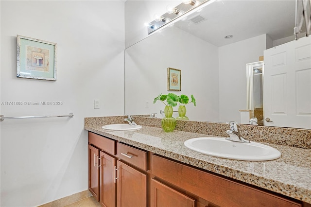 full bath with a sink, visible vents, double vanity, and tile patterned flooring