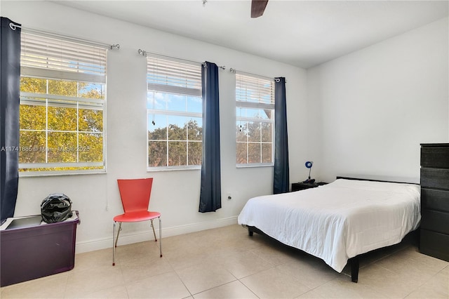 tiled bedroom with baseboards and ceiling fan