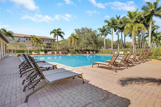 pool with a patio area and fence