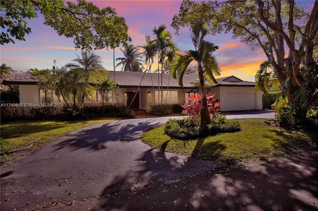 view of front of home featuring a garage and a lawn