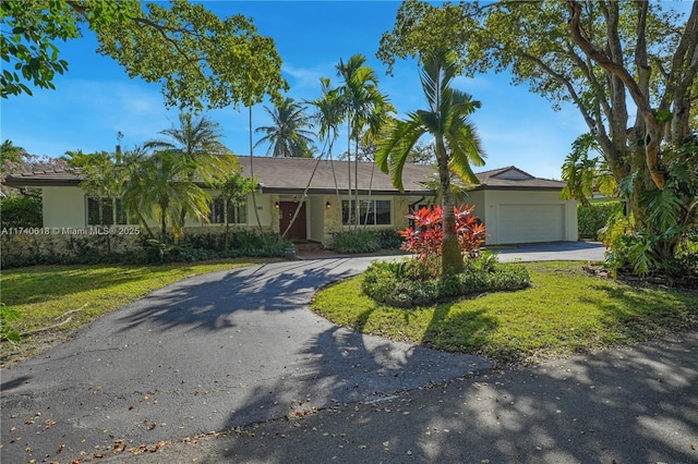 ranch-style home with a garage and a front yard