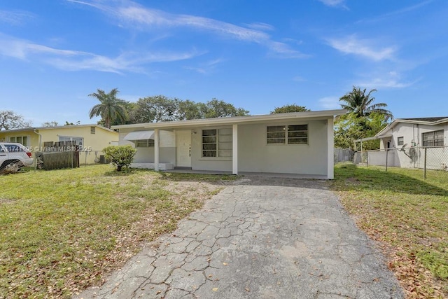 ranch-style house with a front yard, fence, and stucco siding