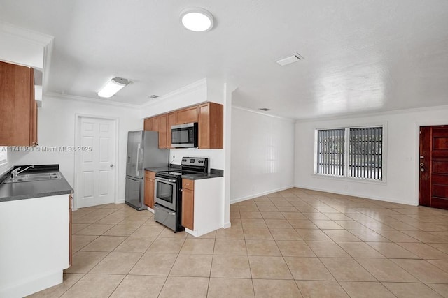 kitchen with brown cabinets, crown molding, stainless steel appliances, dark countertops, and light tile patterned flooring