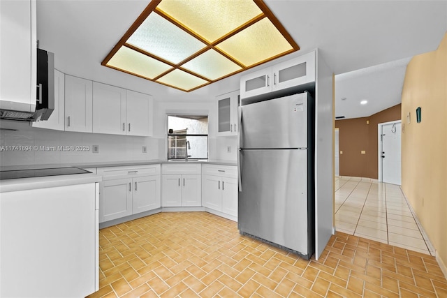 kitchen with sink, white cabinetry, tasteful backsplash, range, and stainless steel fridge