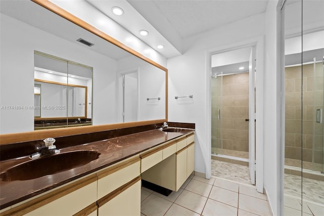 bathroom featuring vanity, tile patterned flooring, and a shower with door