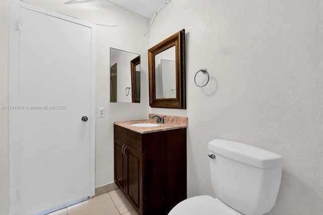 bathroom with vanity, tile patterned flooring, and toilet