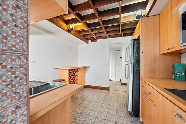 kitchen featuring stainless steel appliances, coffered ceiling, and beam ceiling