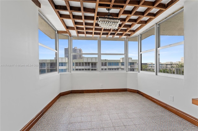 unfurnished sunroom with beam ceiling, coffered ceiling, and an inviting chandelier