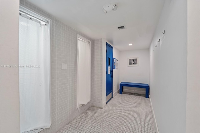 hall featuring light tile patterned floors